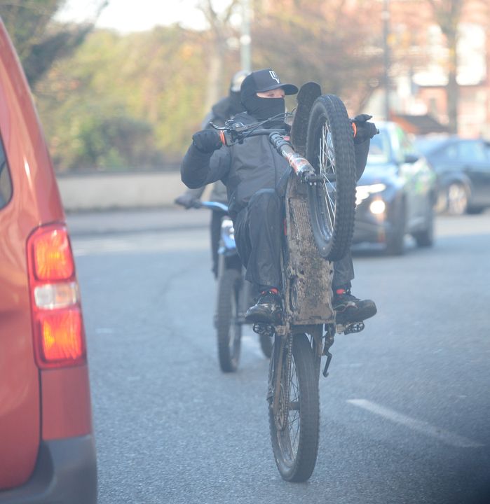 A motorbike rider pulls a wheelie at the funeral of Brandon Ledwidge