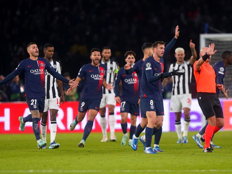 Paris Saint-Germain players surround referee Szymon Marciniak as they appeal for a penalty (Owen Humphreys/PA)