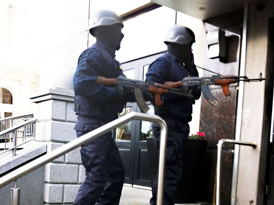 Gunmen hold the AKs that were found in a car the day after the Regency killing